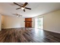 Spacious living room features a decorative wood fireplace, two ceiling fans, and wood flooring at 3312 Victory Palm Dr, Edgewater, FL 32141