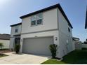 Two-story home featuring a gray two-car garage, manicured lawn, and tasteful landscaping at 3823 Spruce Creek Dr, Lakeland, FL 33811