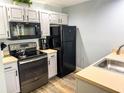 Efficient kitchen featuring stainless steel appliances, light countertops and white painted cabinets at 4011 Venetian Bay Village # 104, Kissimmee, FL 34741