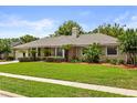 Beautiful single-story home with lush green lawn and mature landscaping creating a serene curb appeal at 548 Timber Ridge Dr, Longwood, FL 32779