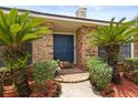 Inviting front entrance featuring a brick walkway leading to a blue door framed by lush greenery at 548 Timber Ridge Dr, Longwood, FL 32779