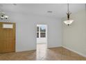 Open living area featuring tile floors, neutral walls, and a doorway with natural light at 5852 Mariposa Cove Ln, Orlando, FL 32822