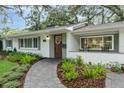 Inviting home exterior with a brick walkway, tidy landscaping, and a charming front entrance with stylish accents at 610 Kittredge Dr, Orlando, FL 32805