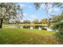 Beautiful backyard view featuring a tranquil pond surrounded by lush greenery and trees at 7621 Brightwater Pl, Oviedo, FL 32765