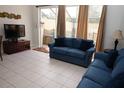 Comfortable living room with large sliding glass doors leading to a screened-in patio at 7682 Sir Kaufmann Ct, Kissimmee, FL 34747