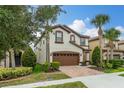 Charming two-story home with a brown garage door and tile roof, complemented by lovely trees and a brick driveway at 8912 Rhodes St, Kissimmee, FL 34747