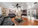 Open-concept living area with hardwood floors, dark leather sofas, ceiling fan, and seamless flow to the kitchen at 9543 Buxton, Orlando, FL 32817