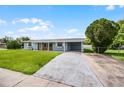 Inviting single story home with a lush green lawn, long driveway and carport at 10800 Fernando St, Orlando, FL 32825