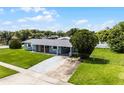 Inviting single story home with a lush green lawn, long driveway and covered parking area at 10800 Fernando St, Orlando, FL 32825