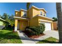 Charming yellow two-story home with a well-manicured lawn and inviting curb appeal on a sunny day at 1129 Royal Ridge Dr, Davenport, FL 33896