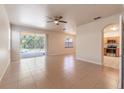 Bright, open living room with tile flooring, ceiling fan, and sliding glass doors leading to the pool at 1129 Royal Ridge Dr, Davenport, FL 33896