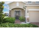 Inviting front entrance featuring a brick path, tasteful landscaping, and a covered porch with stone accents at 1222 Castlevecchio Loop, Orlando, FL 32825