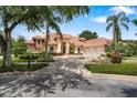 Charming home with terracotta roof, palm trees, manicured lawn, and circular driveway at 1274 Prince Ct, Lake Mary, FL 32746