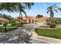 Beautiful home exterior showcasing a terracotta roof, palm trees, manicured lawn, and circular driveway at 1274 Prince Ct, Lake Mary, FL 32746