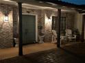 Cozy front porch at night with brick walls, chairs, and a blue door illuminated by classic sconces at 1420 Knollwood St, Orlando, FL 32804
