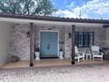 Inviting front porch features brick accents, comfortable seating, and a stylish blue front door at 1420 Knollwood St, Orlando, FL 32804