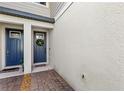 Stylish entryway with a blue front door, wreath decor, and brick pavers at 15577 Willow Arbor Cir, Orlando, FL 32824