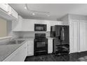 Galley kitchen featuring modern black appliances, sleek countertops, and white cabinetry at 2206 Stonington Ave # 2206, Orlando, FL 32817