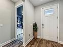 Entryway featuring stylish wood floors, a white door, and an inviting view into a bedroom at 2247 Marsh Sedge Ln, Winter Park, FL 32792