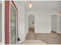 Bright entryway with tile flooring transitions to carpet, showcasing an arched doorway and spacious, open layout at 295 Maguire St, Deltona, FL 32725