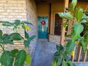 Close-up of a teal front door with a wreath and lush greenery framing the entrance to the home at 3021 Norvell Ct, Deltona, FL 32738