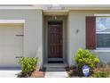 Close-up of the inviting front entrance with a dark-stained front door, and security camera above at 3936 Silverstream Ter, Sanford, FL 32771