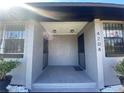 View of the gray painted entrance featuring security doors, white gravel and decorative shrubs at 4204 Columbia St, Orlando, FL 32811