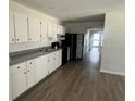A kitchen with white cabinets, grey counter tops, and an open entrance to a hallway at 4204 Columbia St, Orlando, FL 32811