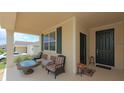 View of covered front porch with cushioned seating area, perfect for enjoying the outdoors at 4858 Magnetite Loop, Mount Dora, FL 32757
