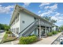 Exterior view of condo with gray staircases and well-maintained landscaping, showcasing a charming and inviting facade at 4890 Conway Rd # 66, Orlando, FL 32812