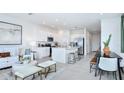 Open-concept living area with white kitchen, island seating, and modern decor at 7811 Waterscape Dr, Groveland, FL 34736