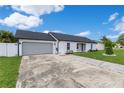 Single-story home with gray garage door, white painted brick and landscaped yard at 8111 Lianna Dr, Orlando, FL 32822
