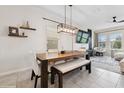 Modern dining room with a wooden table, bench seating, and stylish pendant lighting at 8955 Fluffy Lie Ct, Davenport, FL 33896