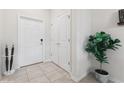 Bright foyer featuring tiled floors, closet space, and a decorative potted plant at 8955 Fluffy Lie Ct, Davenport, FL 33896