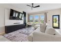 Cozy living room with large windows, plush seating, and contemporary entertainment center at 8955 Fluffy Lie Ct, Davenport, FL 33896