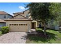 Charming two-story home featuring a tile roof, brick driveway, and well-maintained landscaping at 9023 Shadow Mountain St, Davenport, FL 33896