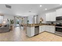This open concept kitchen with stainless steel appliances has an eat-in kitchen, a dining space and an adjacent living area at 9023 Shadow Mountain St, Davenport, FL 33896