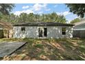 Back of home showing patio doors surrounded by two small windows looking out onto the spacious backyard at 979 Mayfair St, Eustis, FL 32726