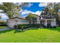 Well-maintained home with a manicured lawn, mature landscaping, and a two-car garage at 1173 Valley Creek Run, Winter Park, FL 32792