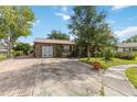 Home exterior featuring brick accents, metal roof, and a paved driveway at 14157 Louisville Ct, Orlando, FL 32826