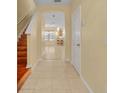 Bright foyer featuring tile flooring that transitions into an open layout with a staircase at 1534 Barking Deer Cv, Casselberry, FL 32707