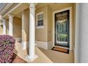 Inviting front porch with decorative wreath, supporting columns, and blooming shrubbery at 1534 Barking Deer Cv, Casselberry, FL 32707
