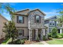 Beautiful two-story home with stone facade, charming shutters, and a well-maintained front yard at 15448 Murcott Blossom Blvd, Winter Garden, FL 34787