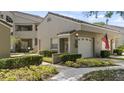 Inviting condo exterior showcasing landscaped garden beds and an attached one-car garage at 165 Durham Pl # 165, Longwood, FL 32779
