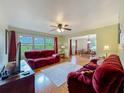 Inviting living room featuring plush red sofas, ample natural light, and wood-look floors, creating a cozy atmosphere at 1850 Lakeshore Cir, Longwood, FL 32750