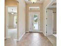 Spacious foyer featuring tiled floors, high ceilings, decorative glass front door, and an open view to other rooms at 207 Spalding Way, Deland, FL 32724