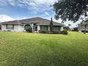 Charming single-story home featuring a well-manicured lawn and mature trees enhancing curb appeal at 23717 Milford Dr, Eustis, FL 32736