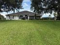 Charming single-story home featuring a well-manicured lawn and mature trees enhancing curb appeal at 23717 Milford Dr, Eustis, FL 32736