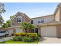 Charming townhouse featuring an attached garage, lush landscaping, and a manicured lawn at 2420 Stockton Dr, Sanford, FL 32771