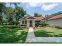 Charming single-story home featuring a well-manicured lawn, inviting walkway, and a classic design at 2426 Breezy Meadow Rd, Apopka, FL 32712